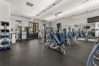 A gym with a variety of equipment including weights and machines.
